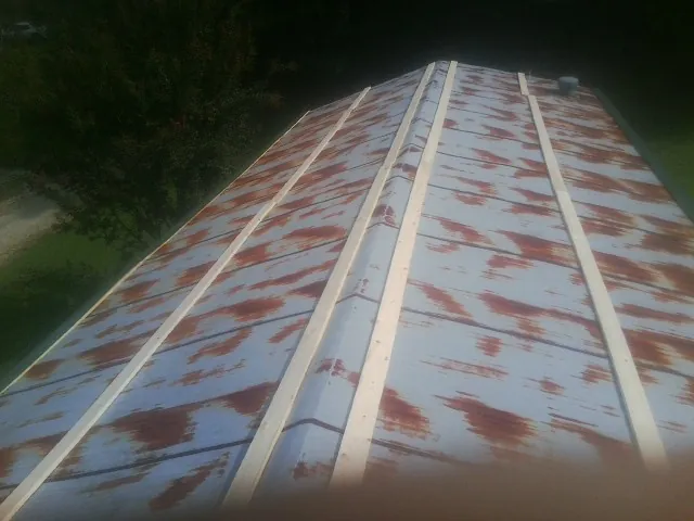 Rusted metal roof panels with new wood purlins before replacement — Storm Damage Roof Repair in Woodbury by Roofing Brothers
